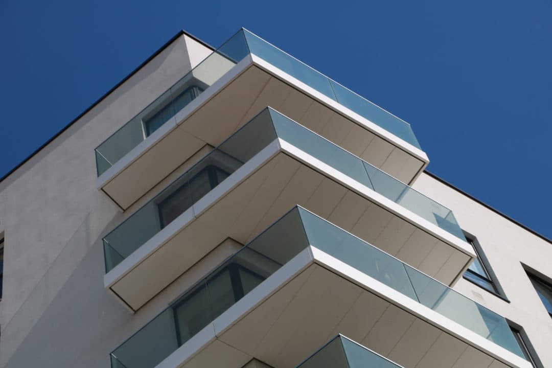 White corner balconies with free edge drainage using controlled drianage in soffits