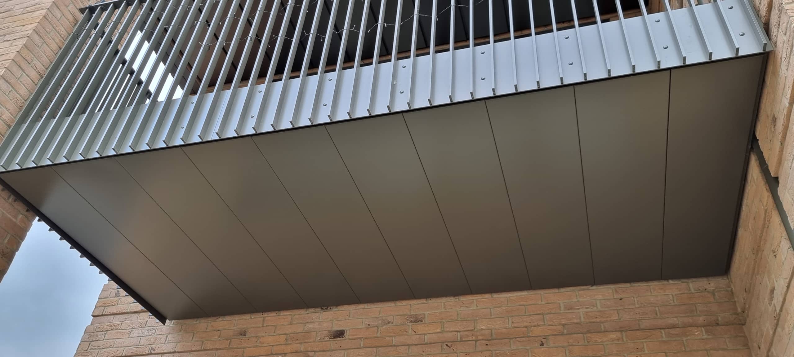 Drainage of an inset balcony using soffits. Balcony recessed between a brick column and a wall